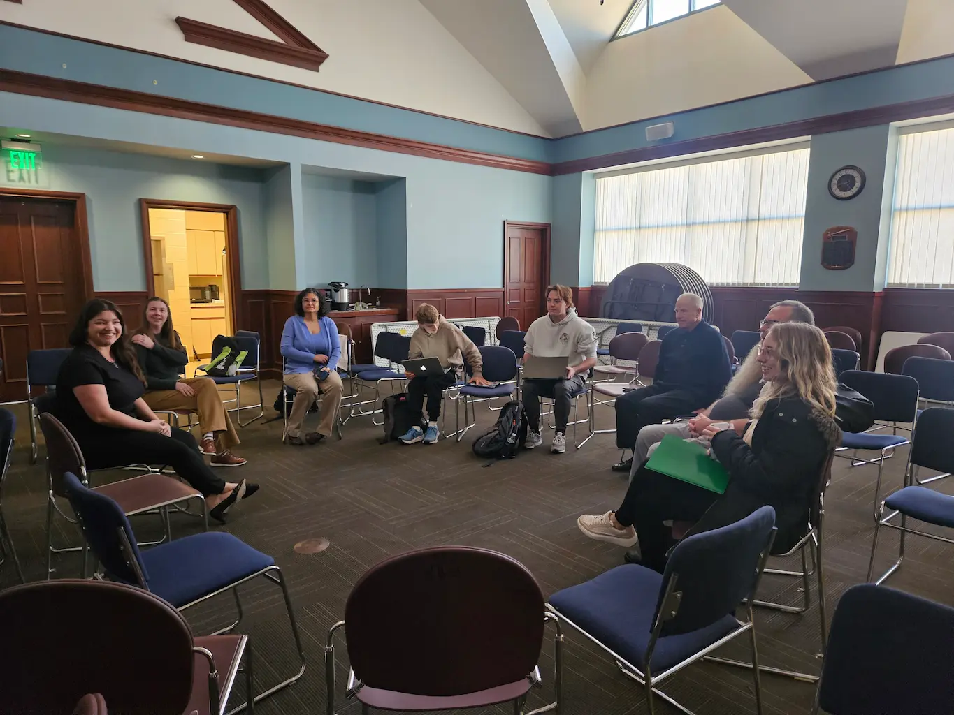 group of people sitting on chairs in a circle